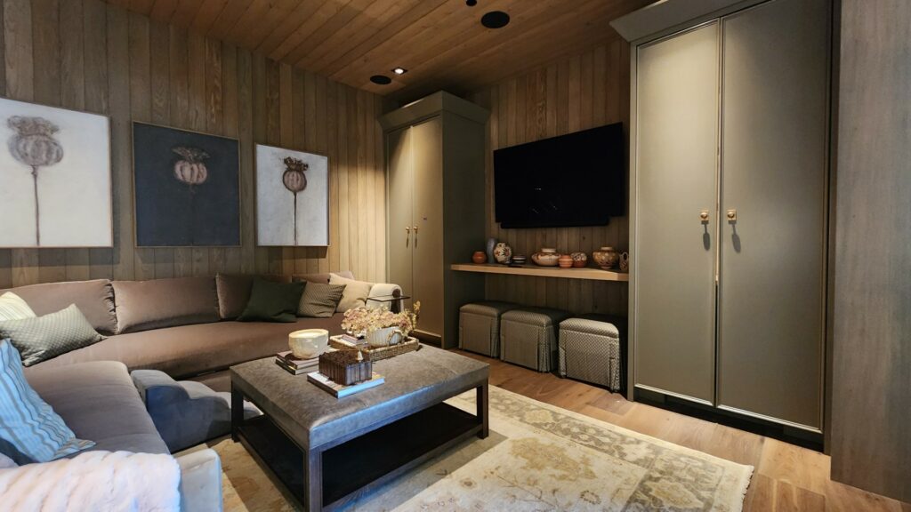 Media room with a wall-mounted TV, soundbar, seating, and built-in cabinetry